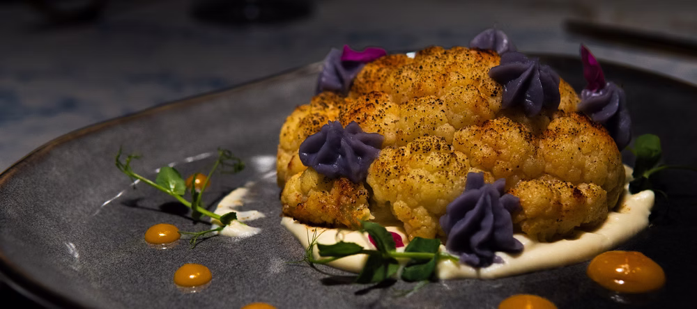 Whole roasted cauliflower with cauliflower puree and micro greens