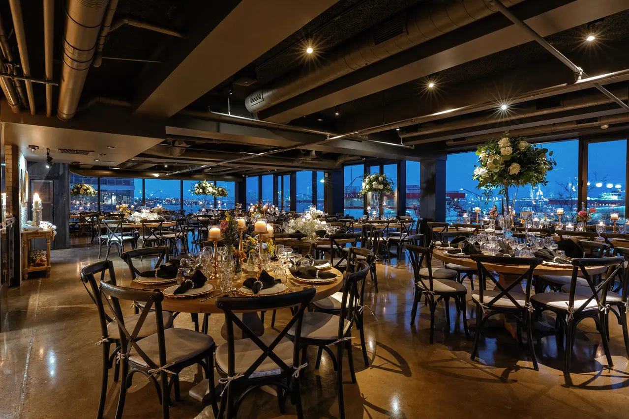The Blue Pearl dining room at night, with the mermaid wall and waterfront windows