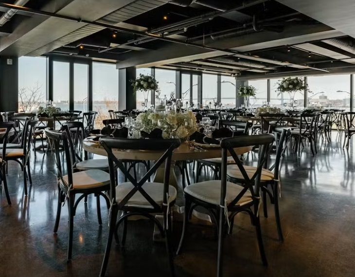 The Loft dressed for a wedding reception, waterfront visible through the windows