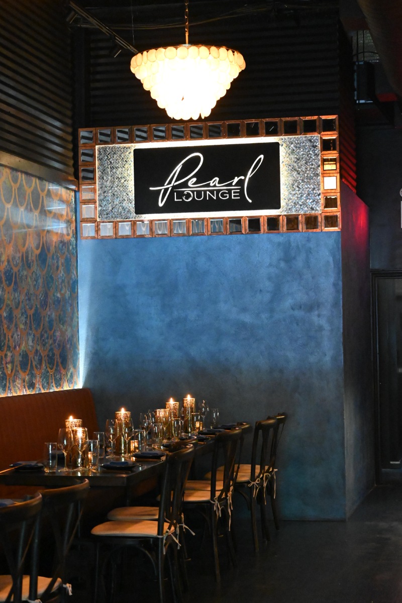The Pearl Lounge, its illuminated sign above a long candlelit table